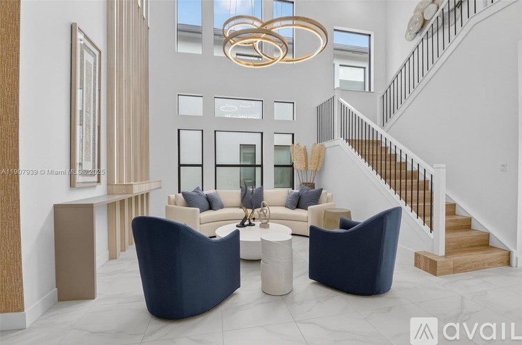 A modern living room with a staircase, a sofa, a chair, and a coffee table.