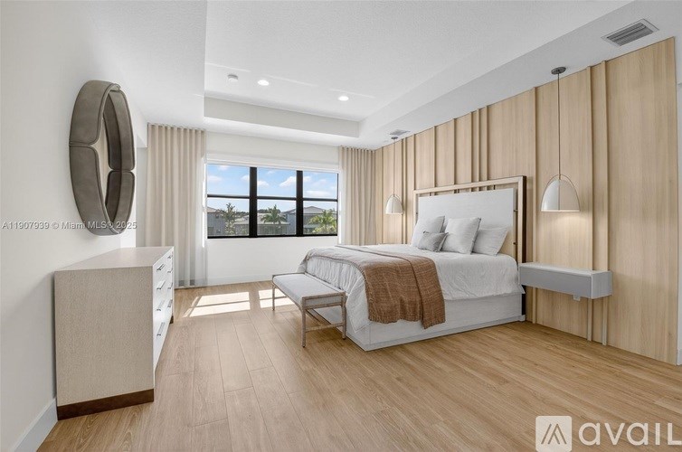 A bedroom with a large bed and a window overlooking the city.