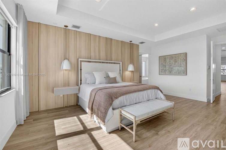 A bedroom with a large bed and a bench.