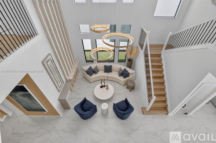 A modern living room with a staircase and a large window.