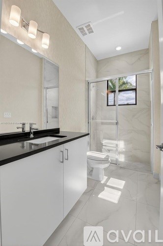 A bathroom with a sink, toilet, and shower.