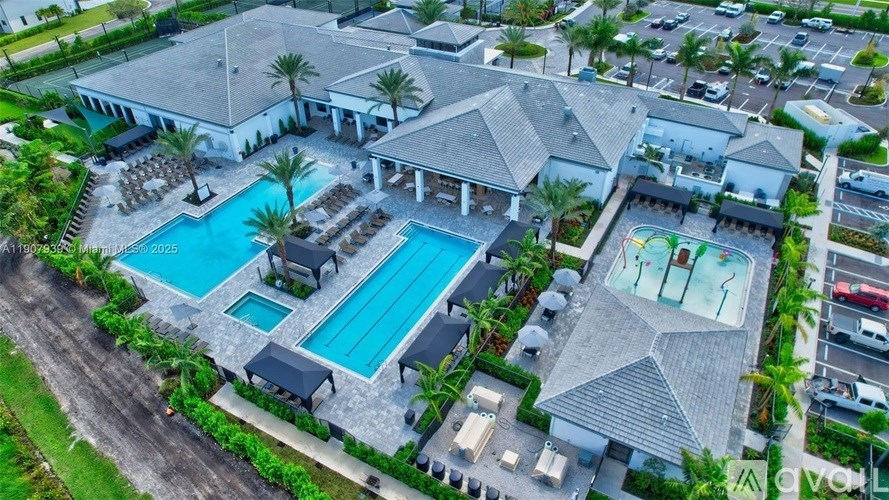 An aerial view of a resort with a large swimming pool and a smaller pool with a waterfall.