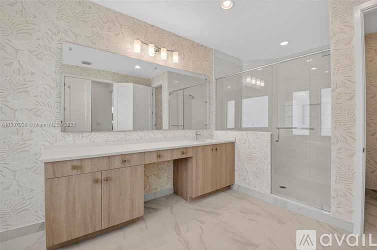 A bathroom with a double sink vanity and a walk-in shower.