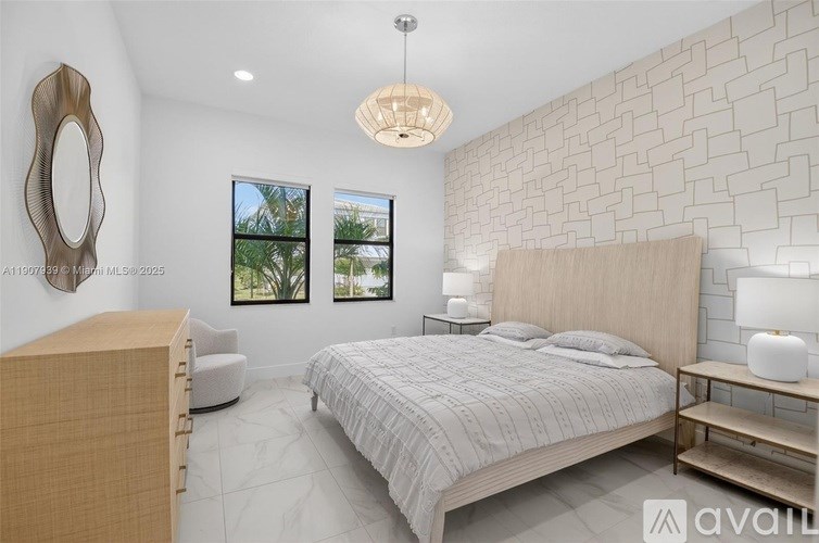A bedroom with a large bed, a wooden dresser, and a white brick wall.