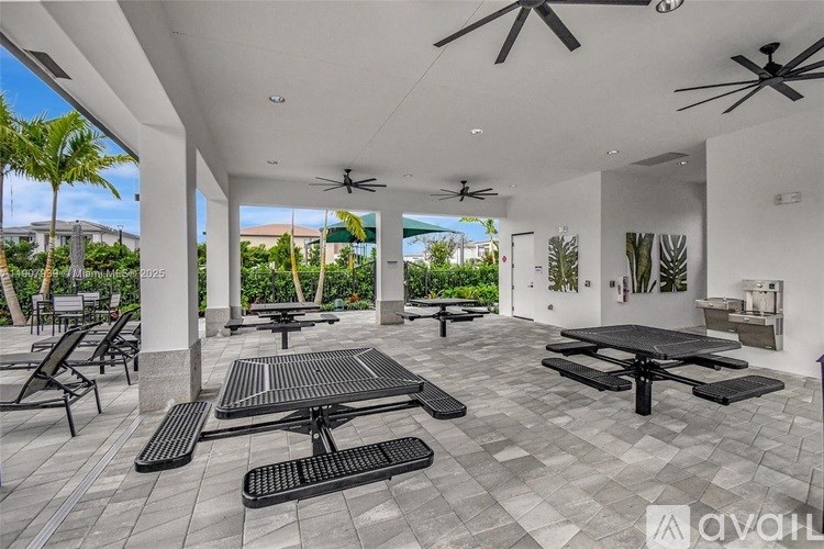 A patio with black furniture and ceiling fans.