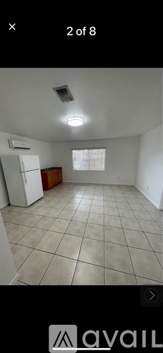 A room with tiled flooring and a window with blinds.