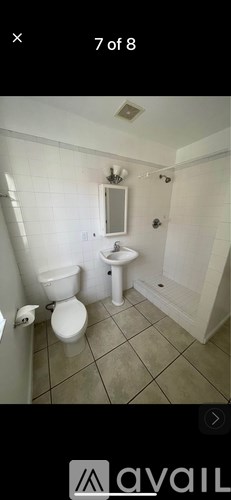 A bathroom with a toilet, sink, and mirror.