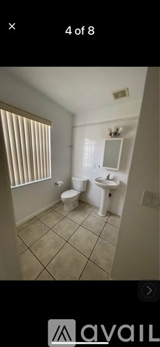 A bathroom with a toilet, sink, and window.