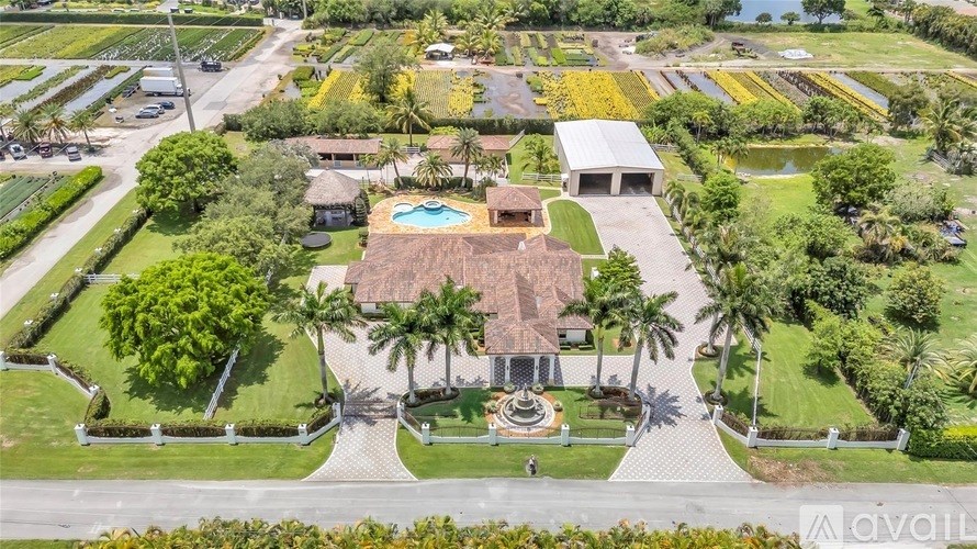 A large, well-manicured estate with a pool and a fountain in the center.