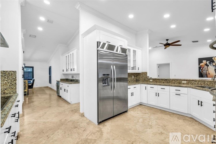 A modern kitchen with a central island and stainless steel appliances.