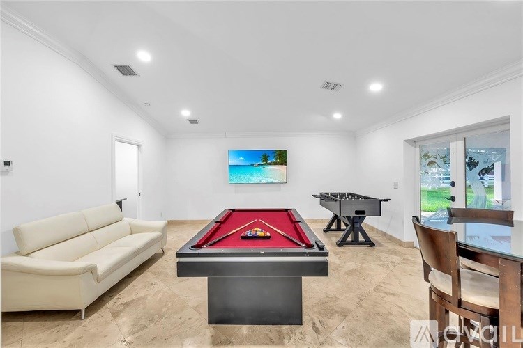 A room with a pool table and a painting on the wall.