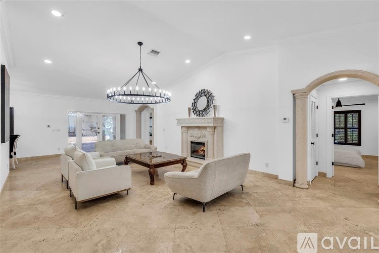 A living room with a fireplace, two couches, and a chandelier.