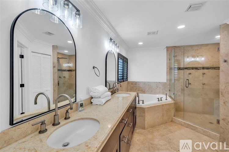 A bathroom with a sink, mirror, and shower.