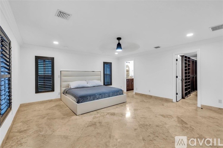 A bedroom with a large bed and a ceiling fan.