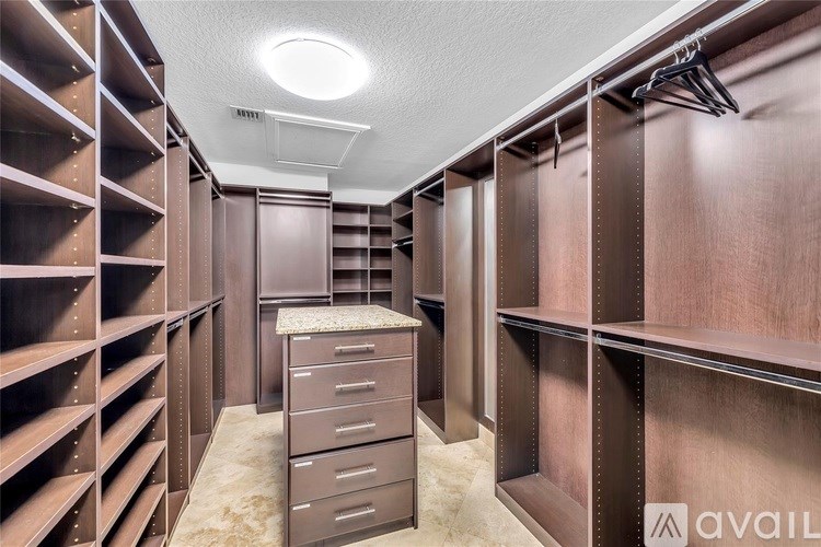 A walk-in closet with brown shelving and drawers.
