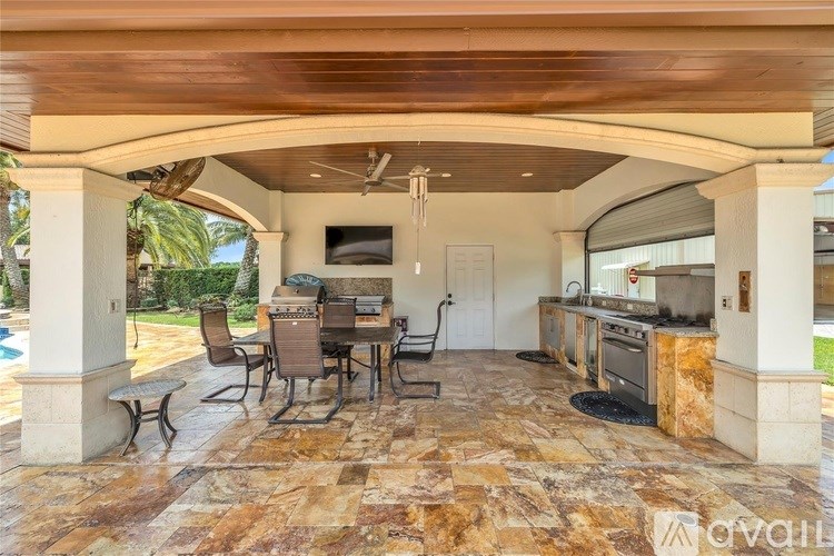 A covered outdoor patio area with a table and chairs.