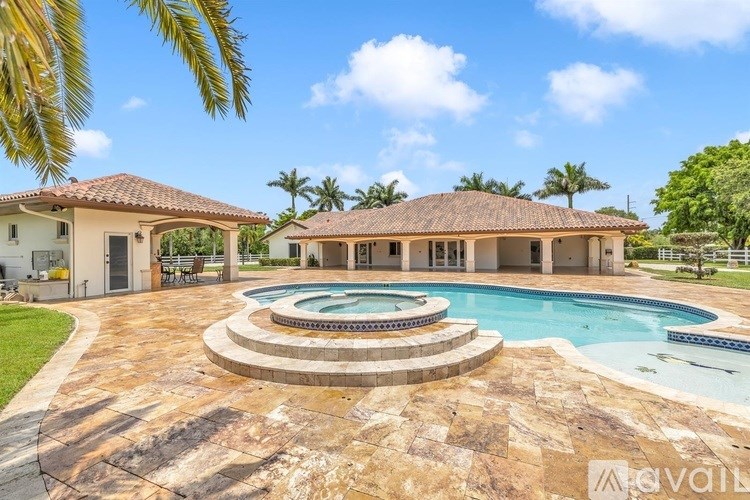 A large house with a pool in the middle of a patio.
