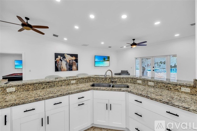 A kitchen with granite countertops and white cabinets.