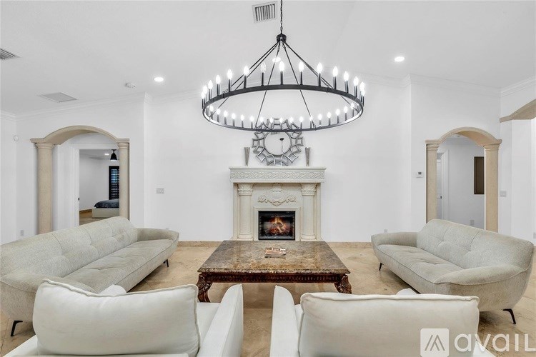 A modern living room with a fireplace and a chandelier.