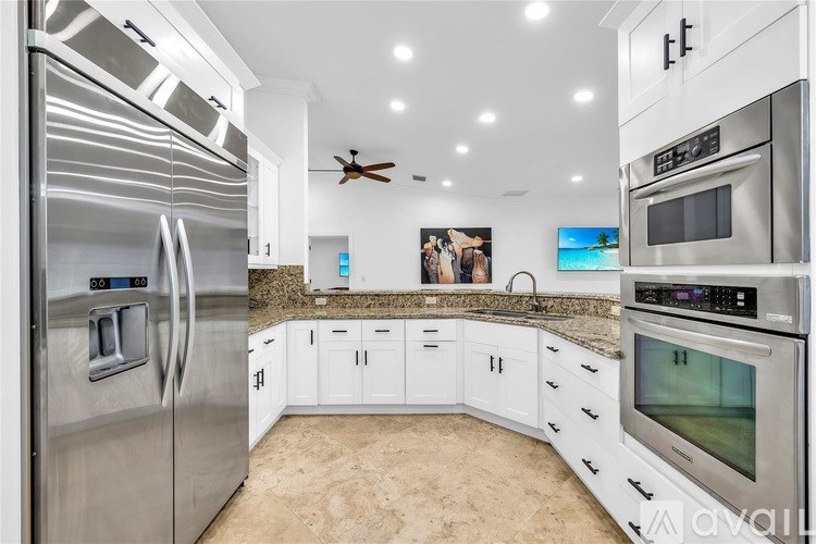 A modern kitchen with stainless steel appliances and white cabinets.