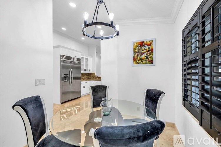 A modern dining room with a glass table and chairs.