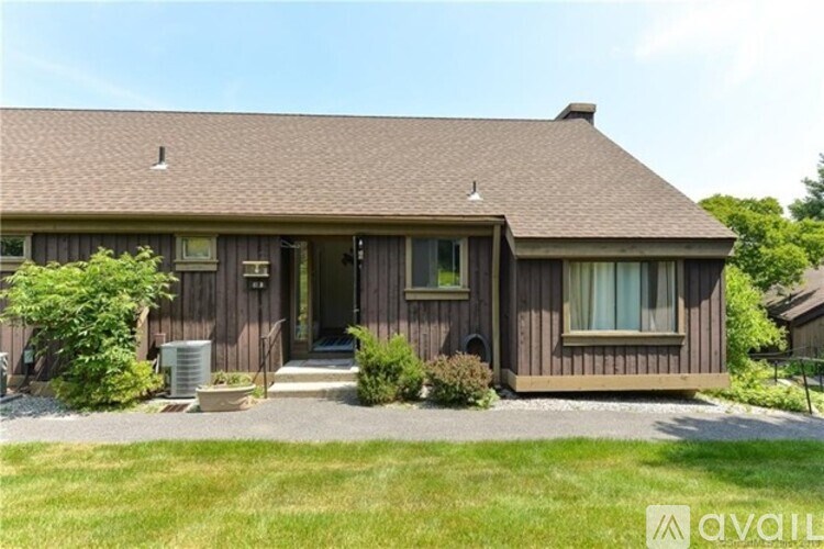 A house with a brown siding and a brown roof with a gutter.