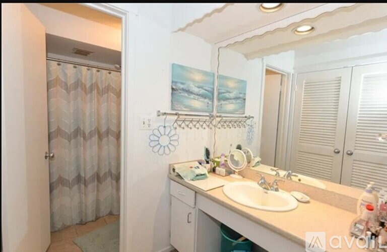 A bathroom with a sink, mirror, and a shower curtain.