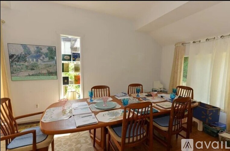 A dining room with a wooden table set for six.