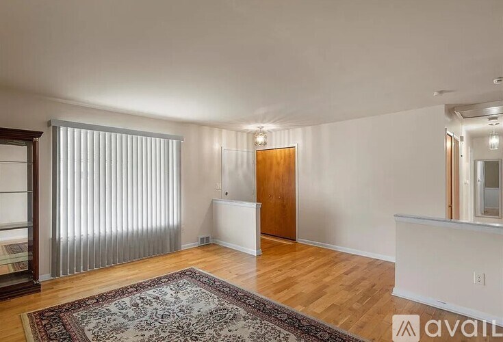 A room with a rug on the floor and a door on the right.