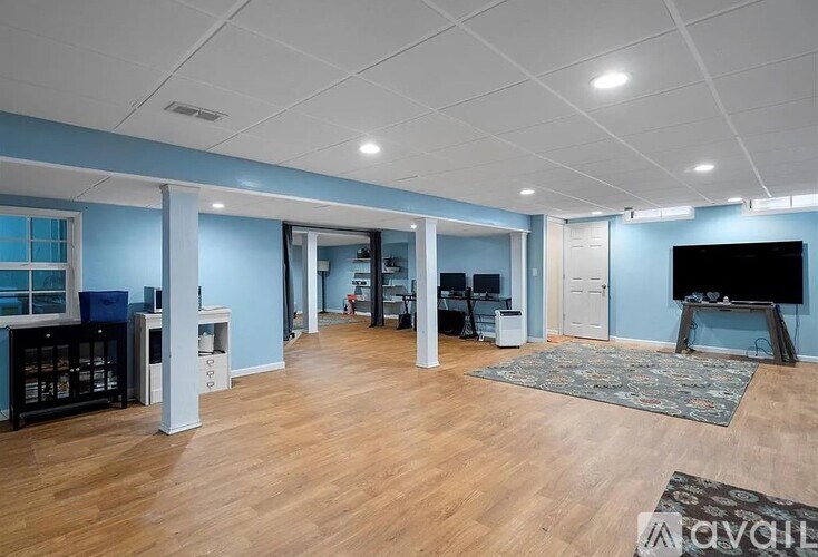 A spacious living room with a television and a rug.