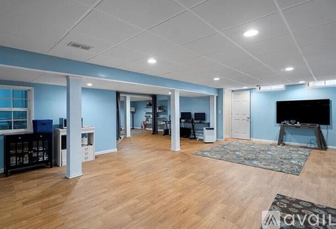 A spacious living room with a television and a rug.