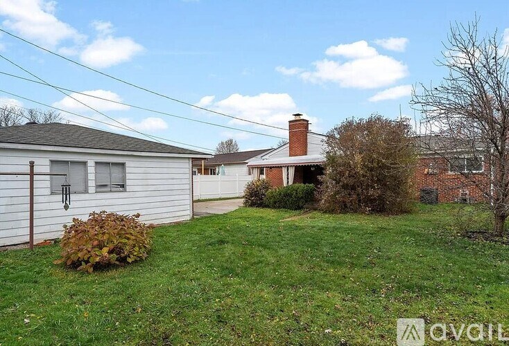 A house with a yard and a tree in front.