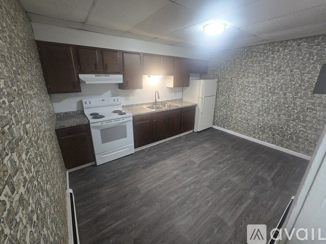 A kitchen with a white stove top oven and a white refrigerator.