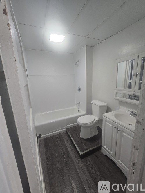 A bathroom with a toilet, sink, and bathtub.