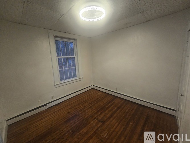 A room with a window and wooden flooring.