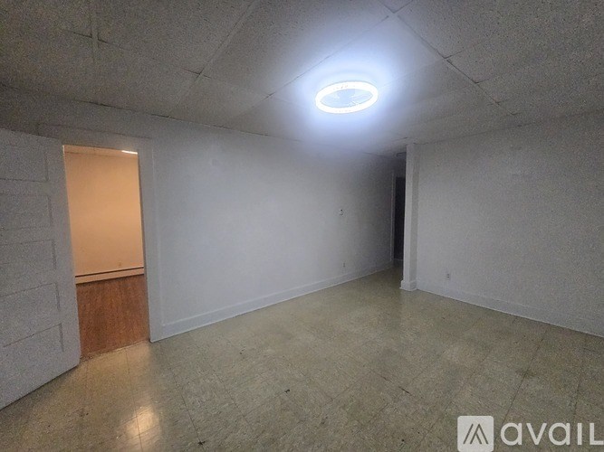 A room with a white wall and a wooden door.