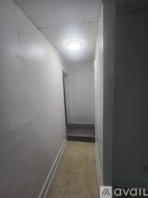 A narrow hallway with a light on the ceiling.