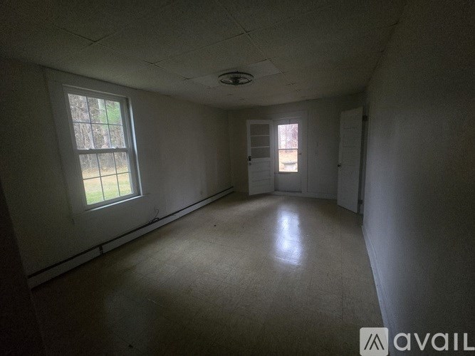 A room with a window and a door is available for rent.
