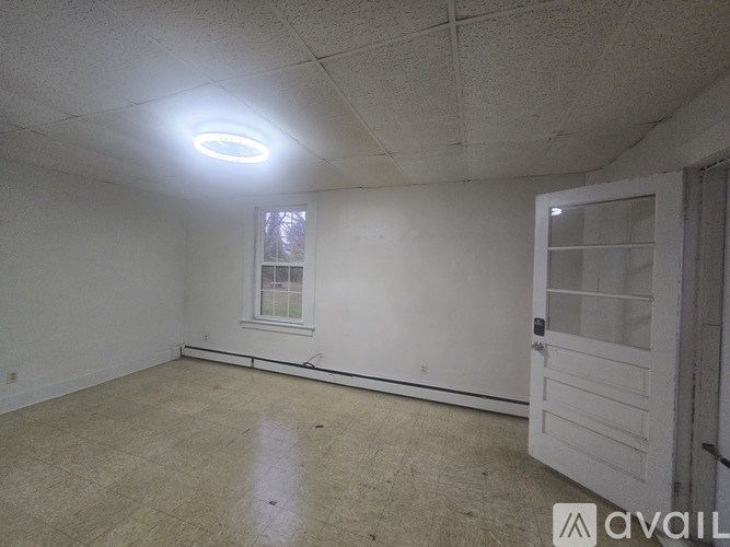 A room with a window and a door is available for rent.