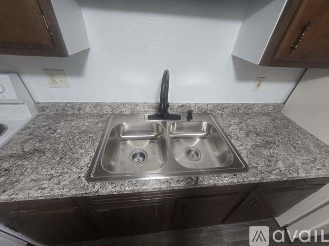 A granite countertop with a double sink and a black faucet.