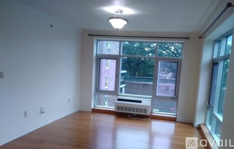A spacious room with a large window and a bench.