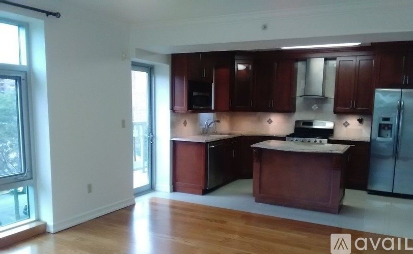 A kitchen with dark wood cabinets and a white island.