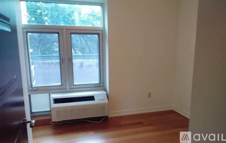 A room with a window and a wall-mounted air conditioner.