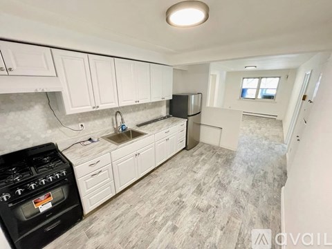 A kitchen with white cabinets and a black stove top oven.