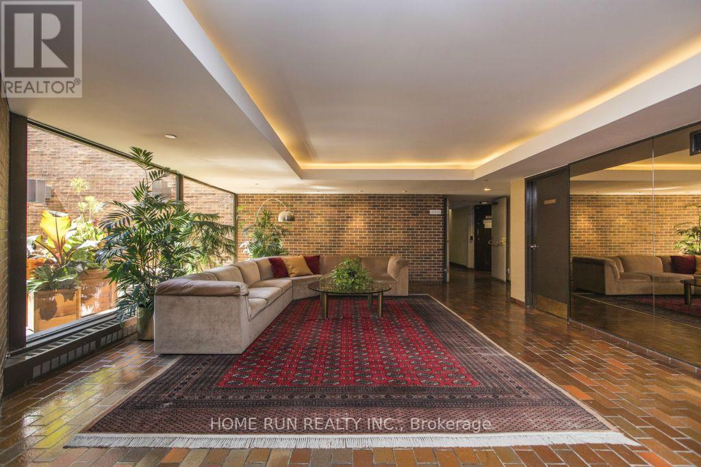 A living room with a red carpet and a brick wall.