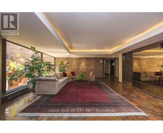 A living room with a red carpet and a brick wall.