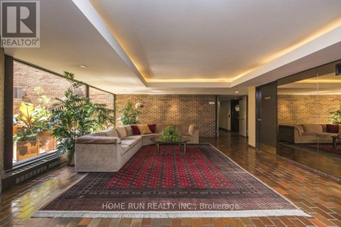 A living room with a red carpet and a brick wall.