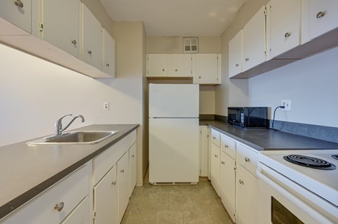 A kitchen with white cabinets and appliances.