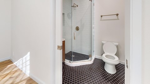 A white toilet in a bathroom with a glass shower door.