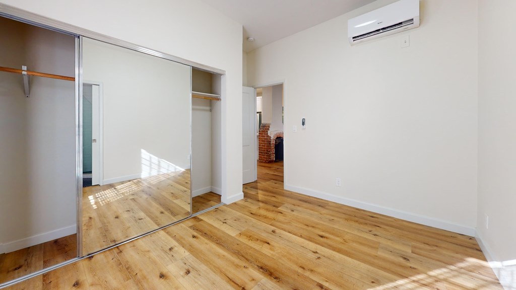 A room with wooden floors and a sliding glass door.